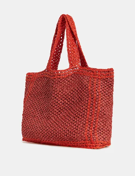 Baksteenrode en oranje shopper in papieren raffia