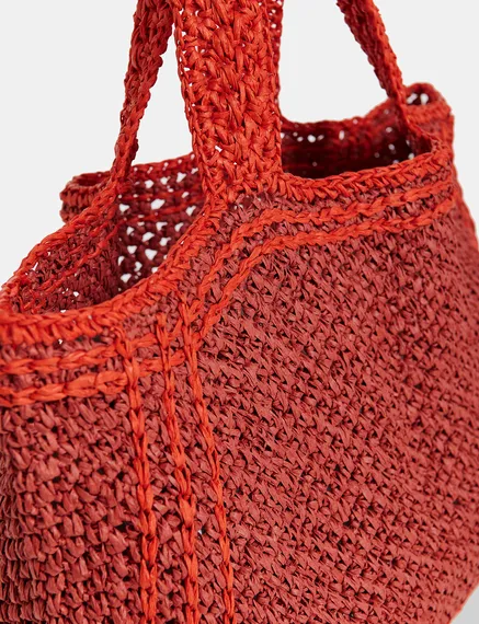 Baksteenrode en oranje shopper in papieren raffia