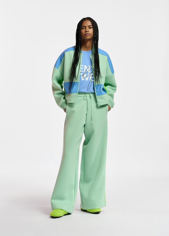 Mint green track pants with black and blue stripes