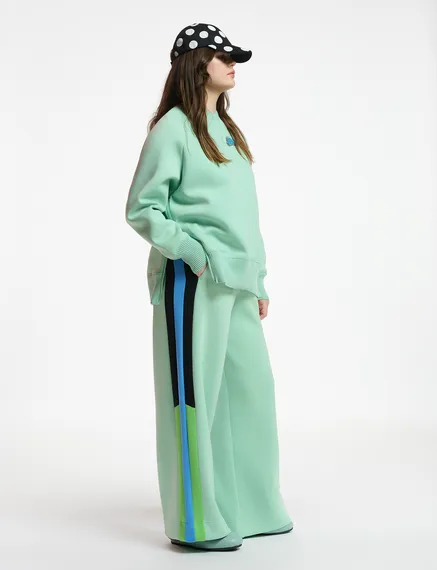 Mint green track pants with black and blue stripes