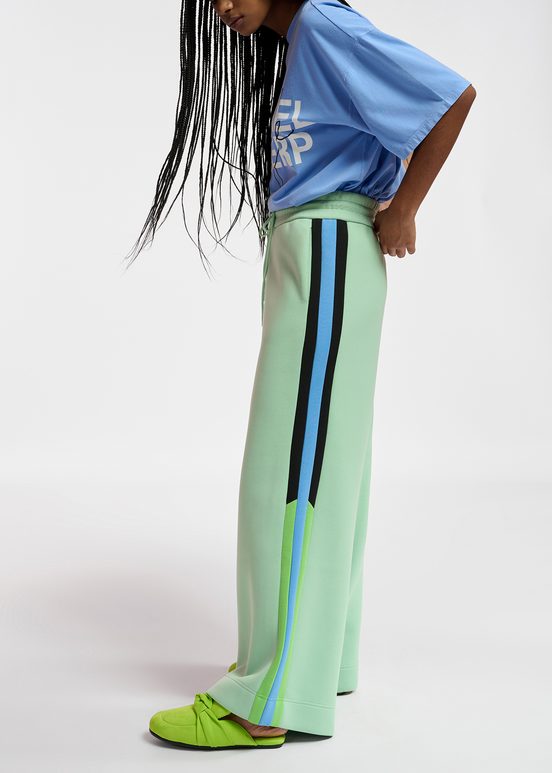 Mint green track pants with black and blue stripes