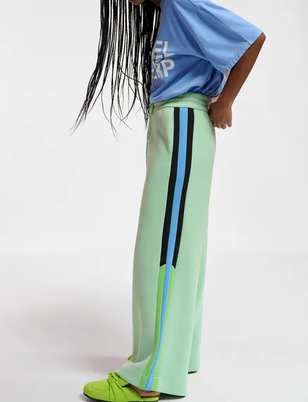 Mint green track pants with black and blue stripes