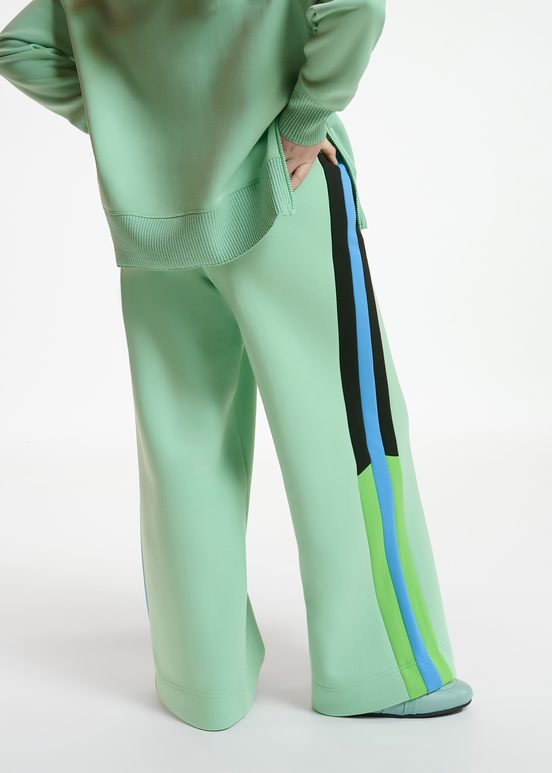 Mint green track pants with black and blue stripes