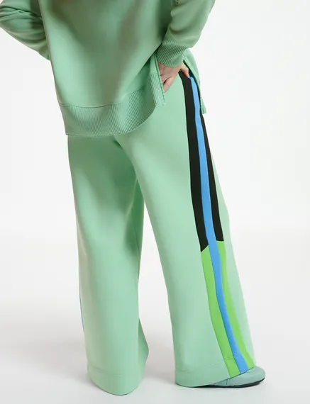 Mint green track pants with black and blue stripes