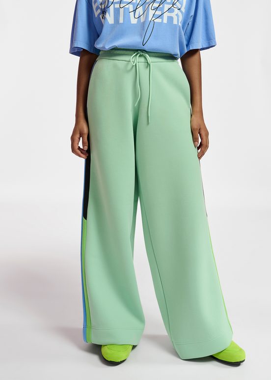 Mint green track pants with black and blue stripes