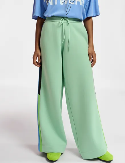 Mint green track pants with black and blue stripes