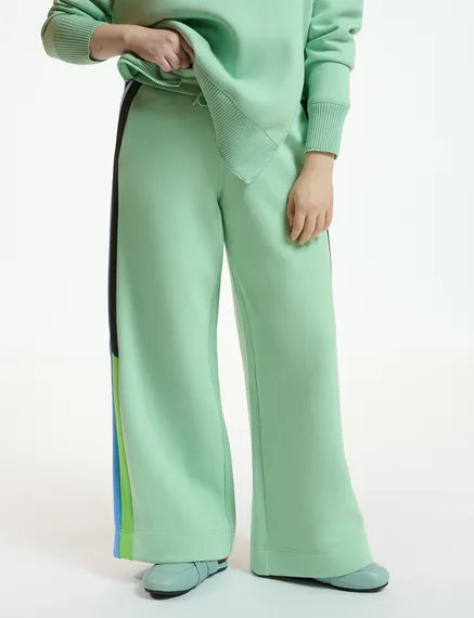 Mint green track pants with black and blue stripes