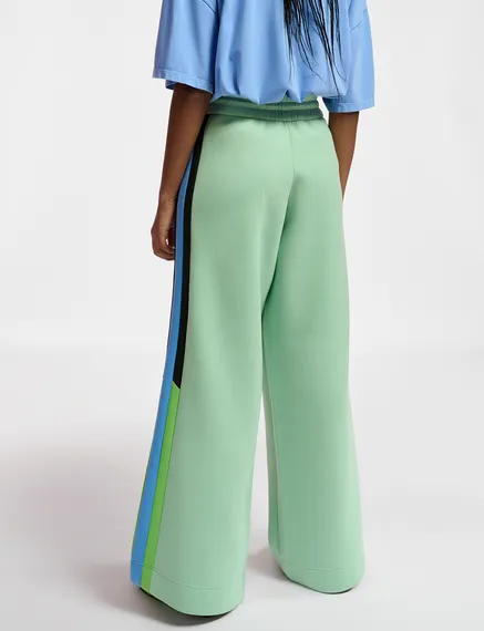 Mint green track pants with black and blue stripes