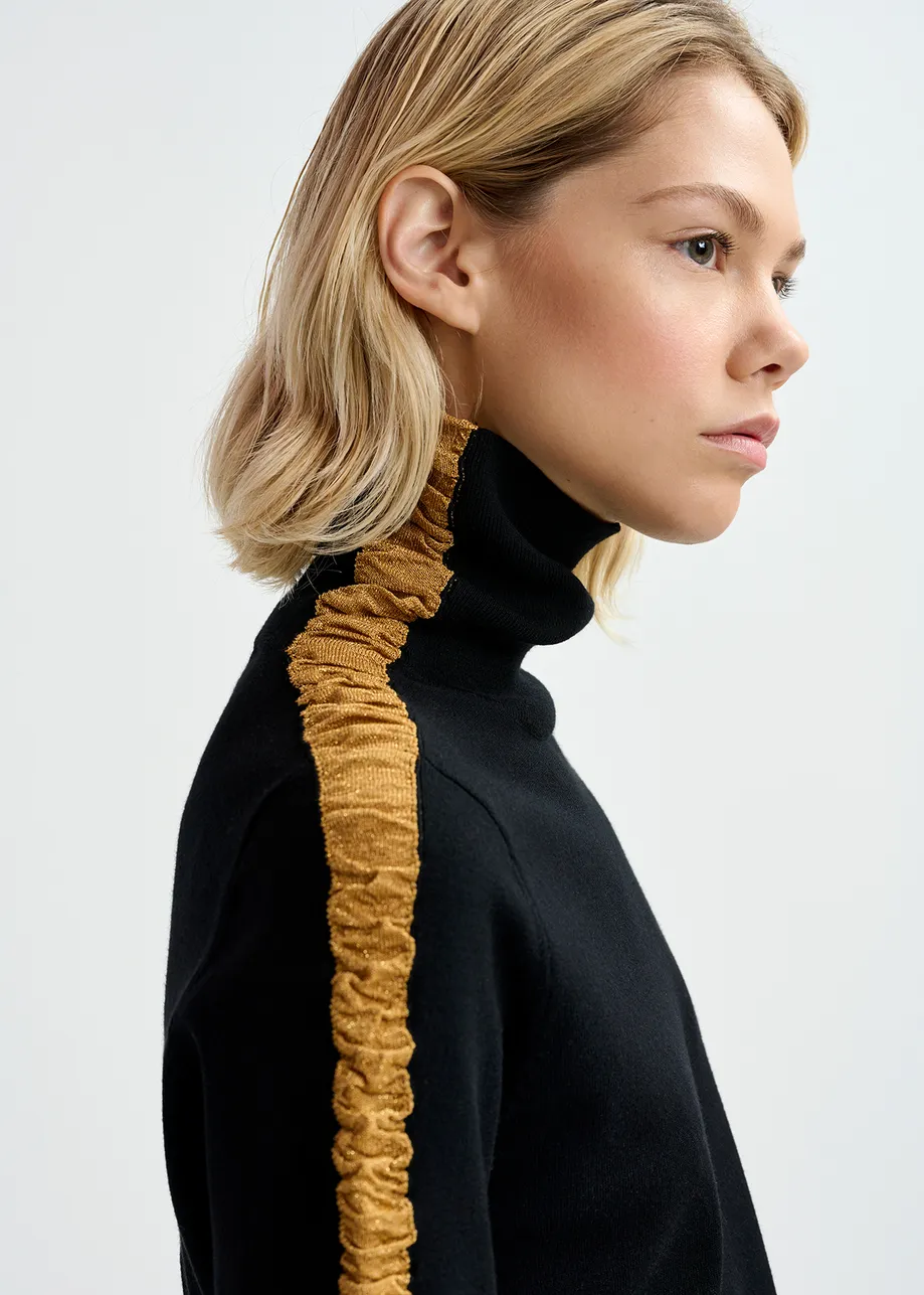 Black turtleneck knit sweater with golden stripes