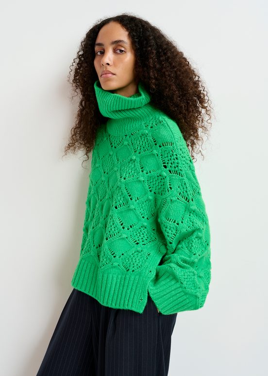 Green cable-knit turtleneck sweater