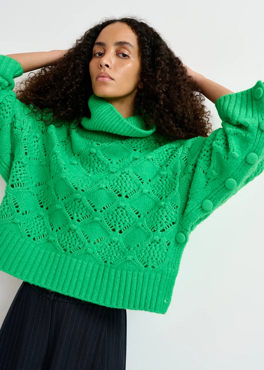 Green cable-knit turtleneck sweater