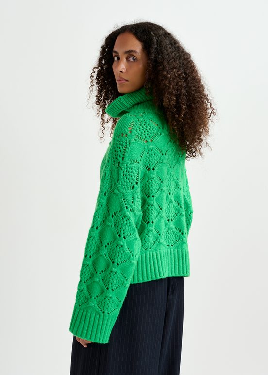 Green cable-knit turtleneck sweater