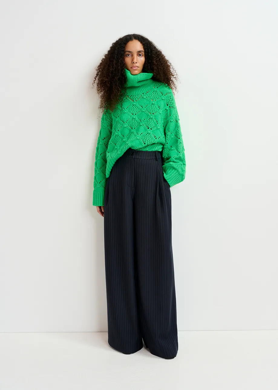 Green cable-knit turtleneck sweater