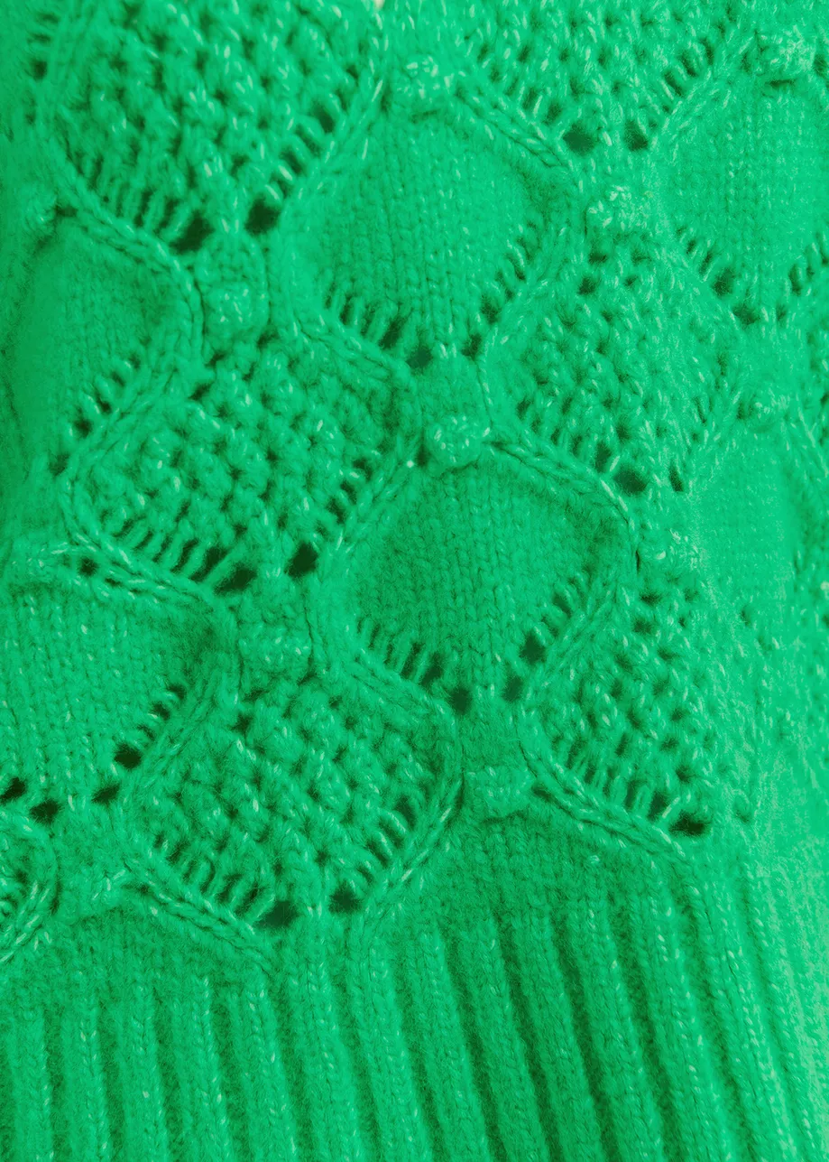 Green cable-knit turtleneck sweater