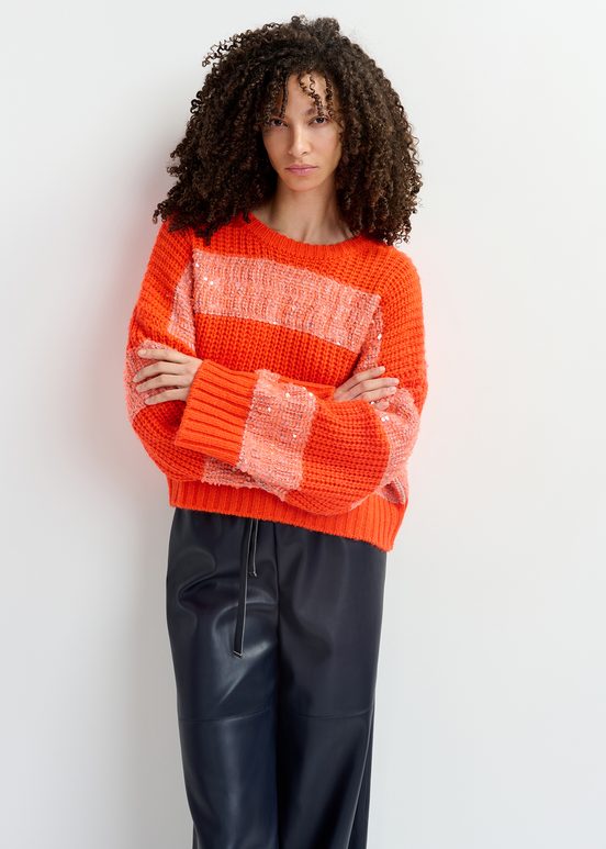 Orangefarbener Strickpullover mit Paillettenstreifen