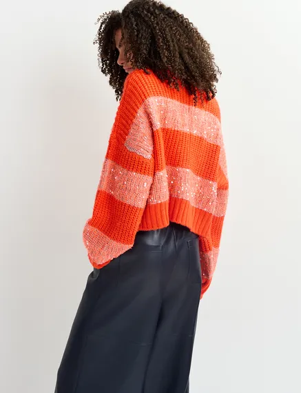 Orangefarbener Strickpullover mit Paillettenstreifen