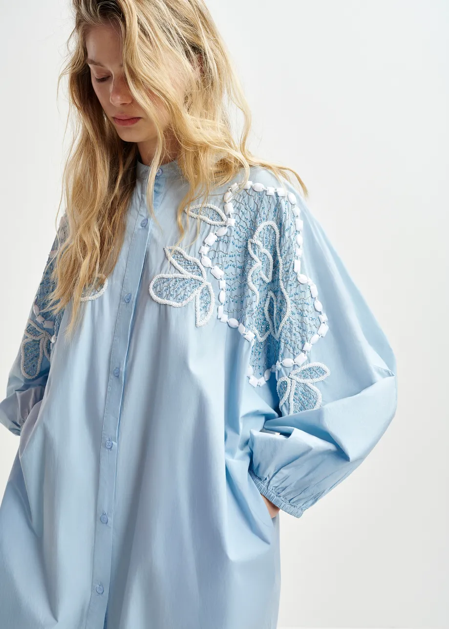 Light blue and white cotton shirt dress with bead embellishments and puffed sleeves