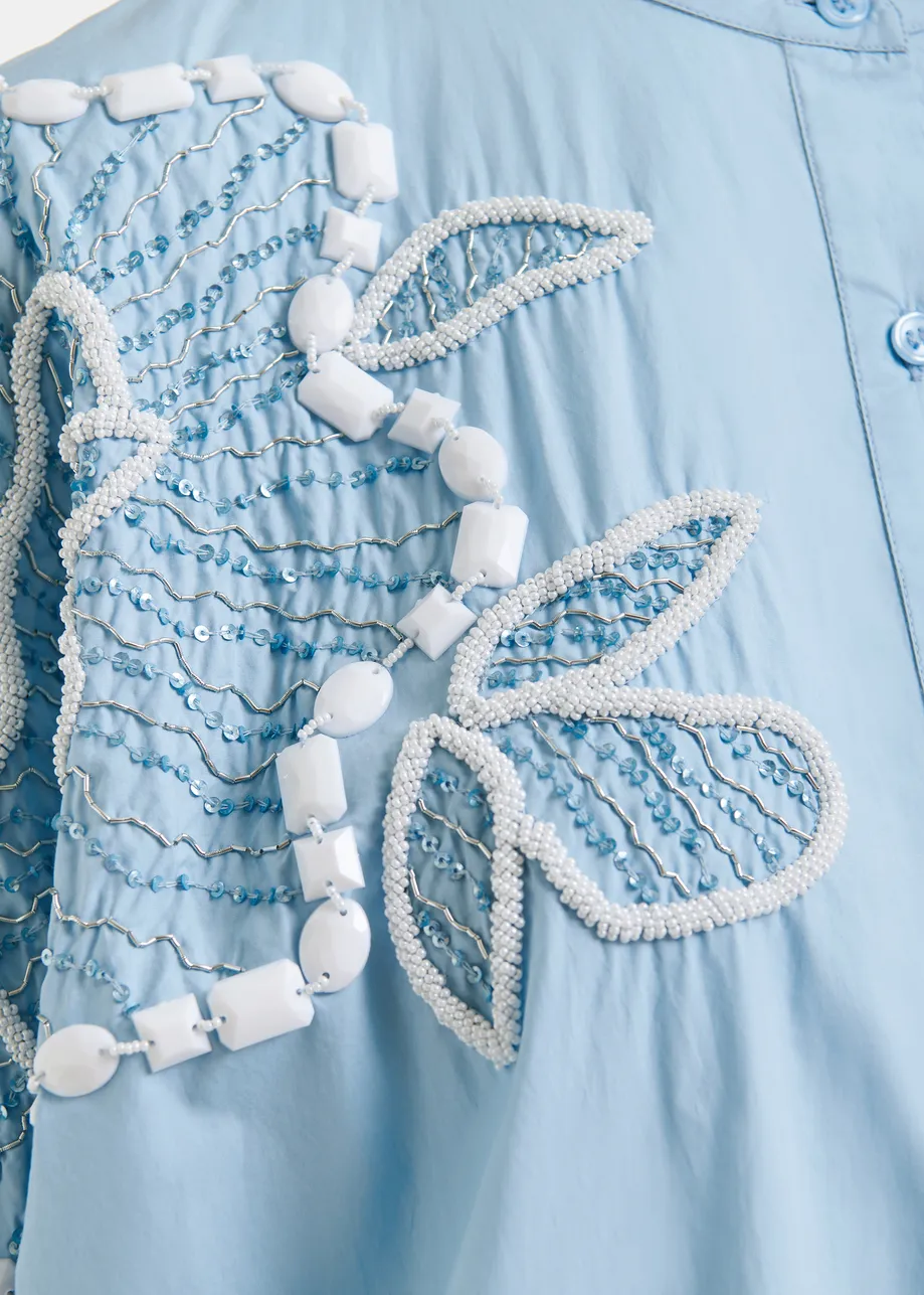 Light blue and white cotton shirt dress with bead embellishments and puffed sleeves