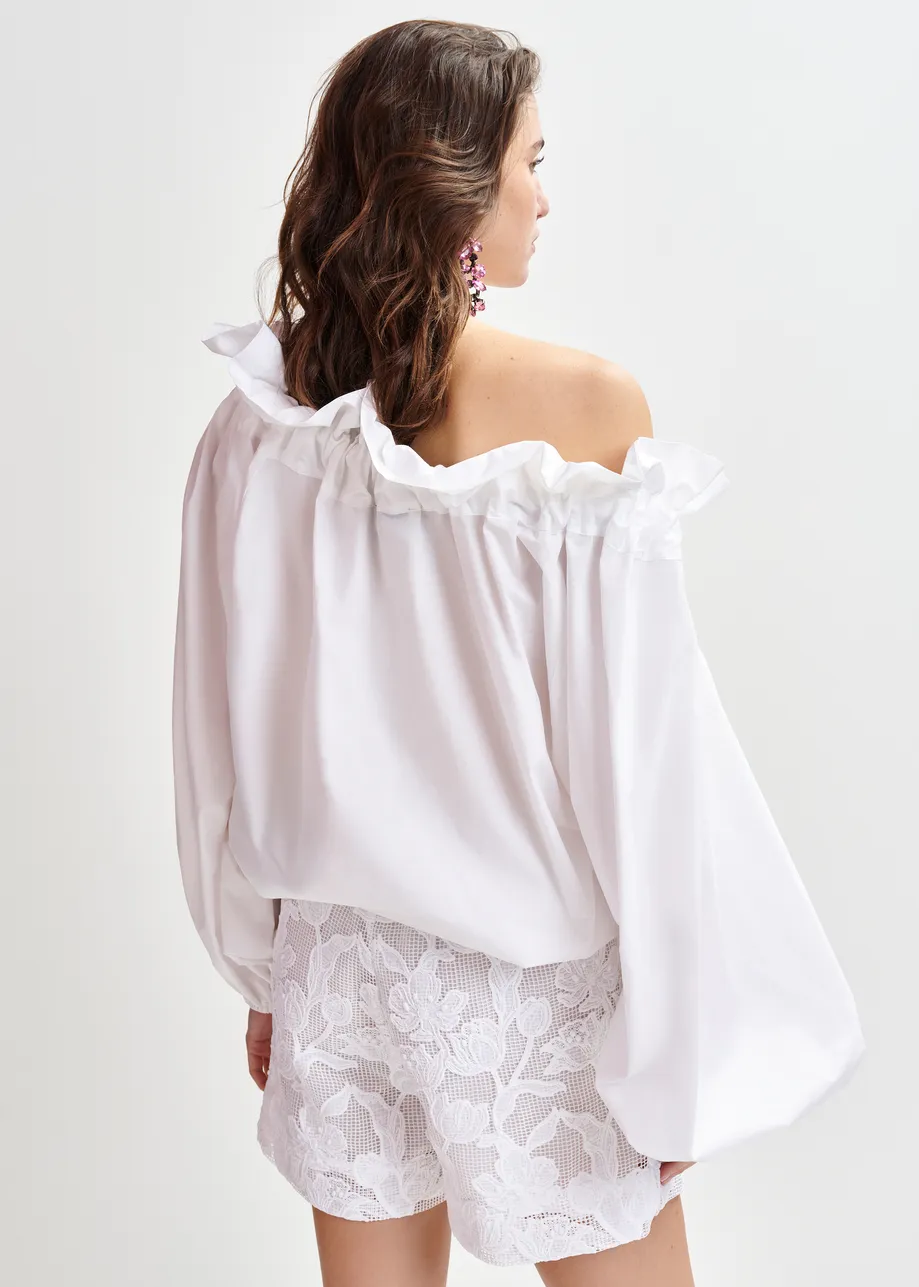 White cotton top with ruffle details, voluminous sleeves, and self-tie collar