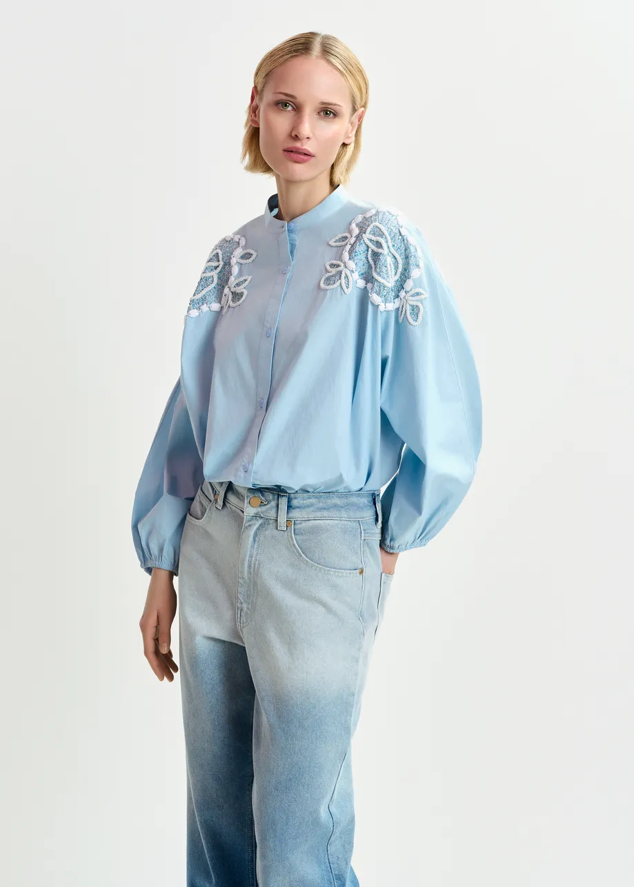 Chemise en coton bleu clair et blanche avec perles et manches bouffantes