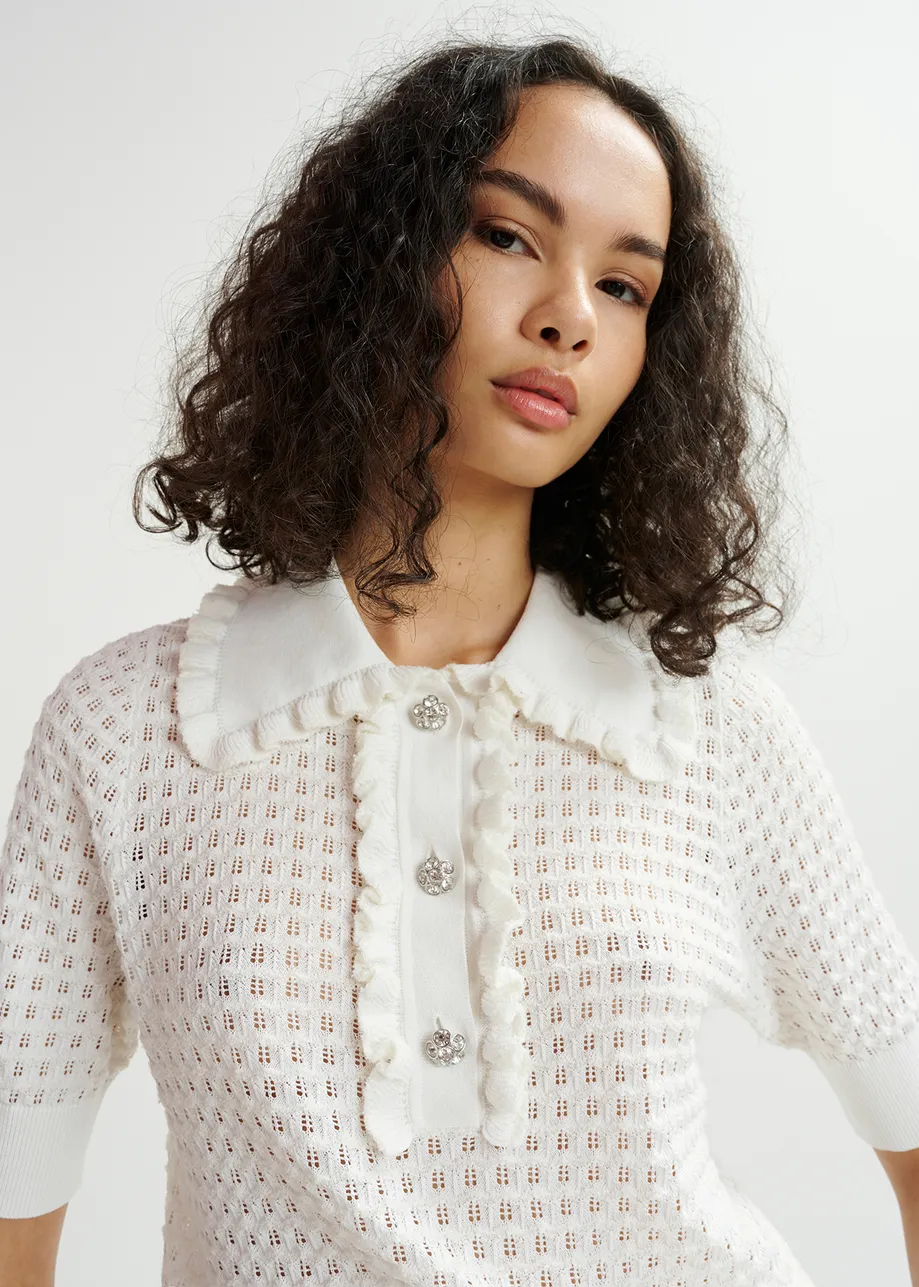 Off-white polo with ruffles and rhinestone-embellished buttons