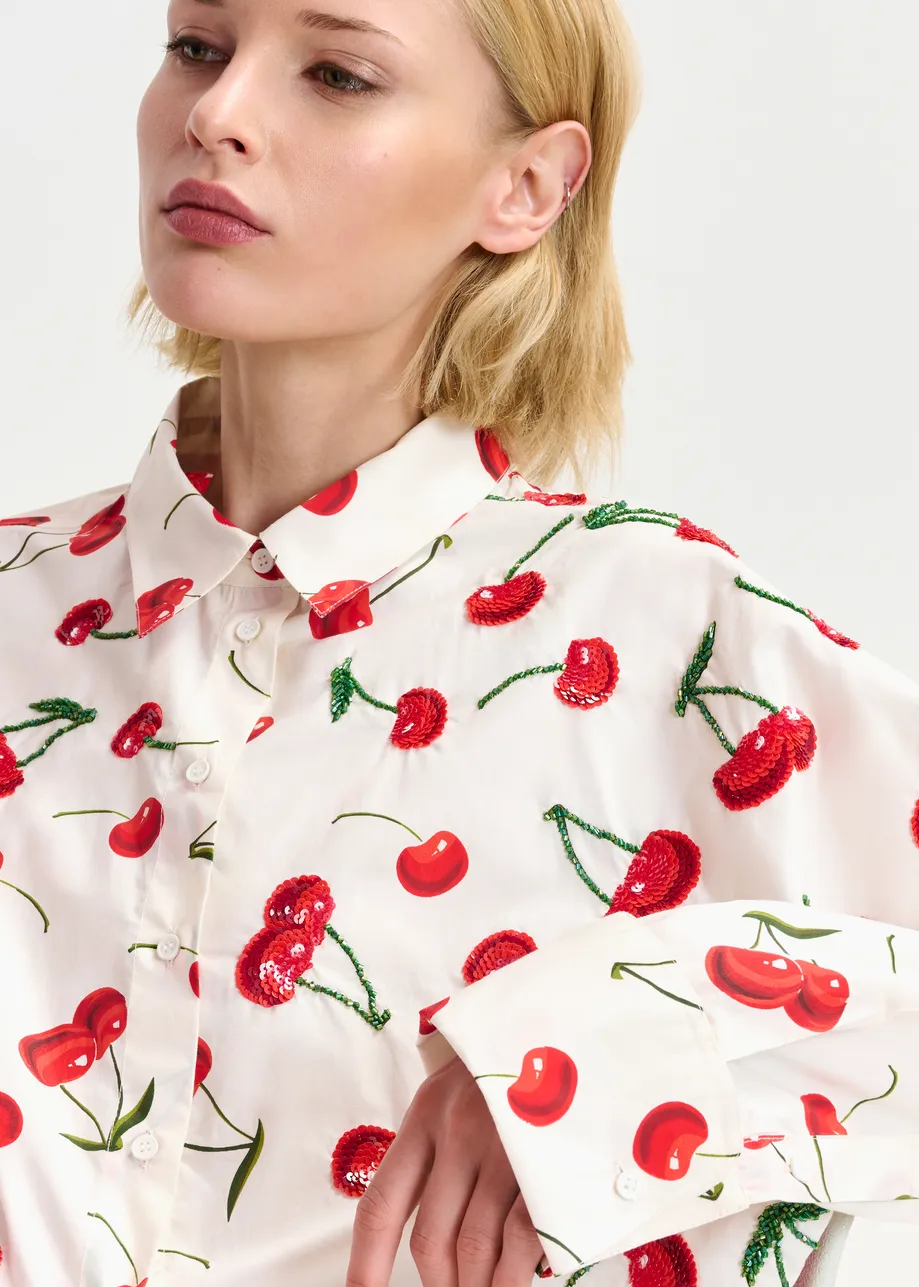 Camicia in cotone bianco, rosso e verde con stampa a ciliegie e decorazioni di paillettes