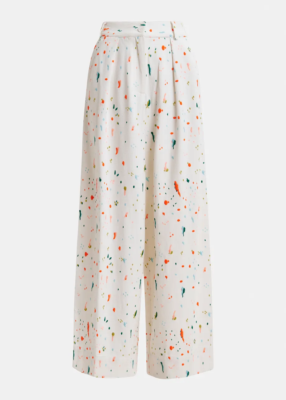 Pantalones de pernera ancha con salpicaduras de pintura bordadas, blanco roto y multicolor.