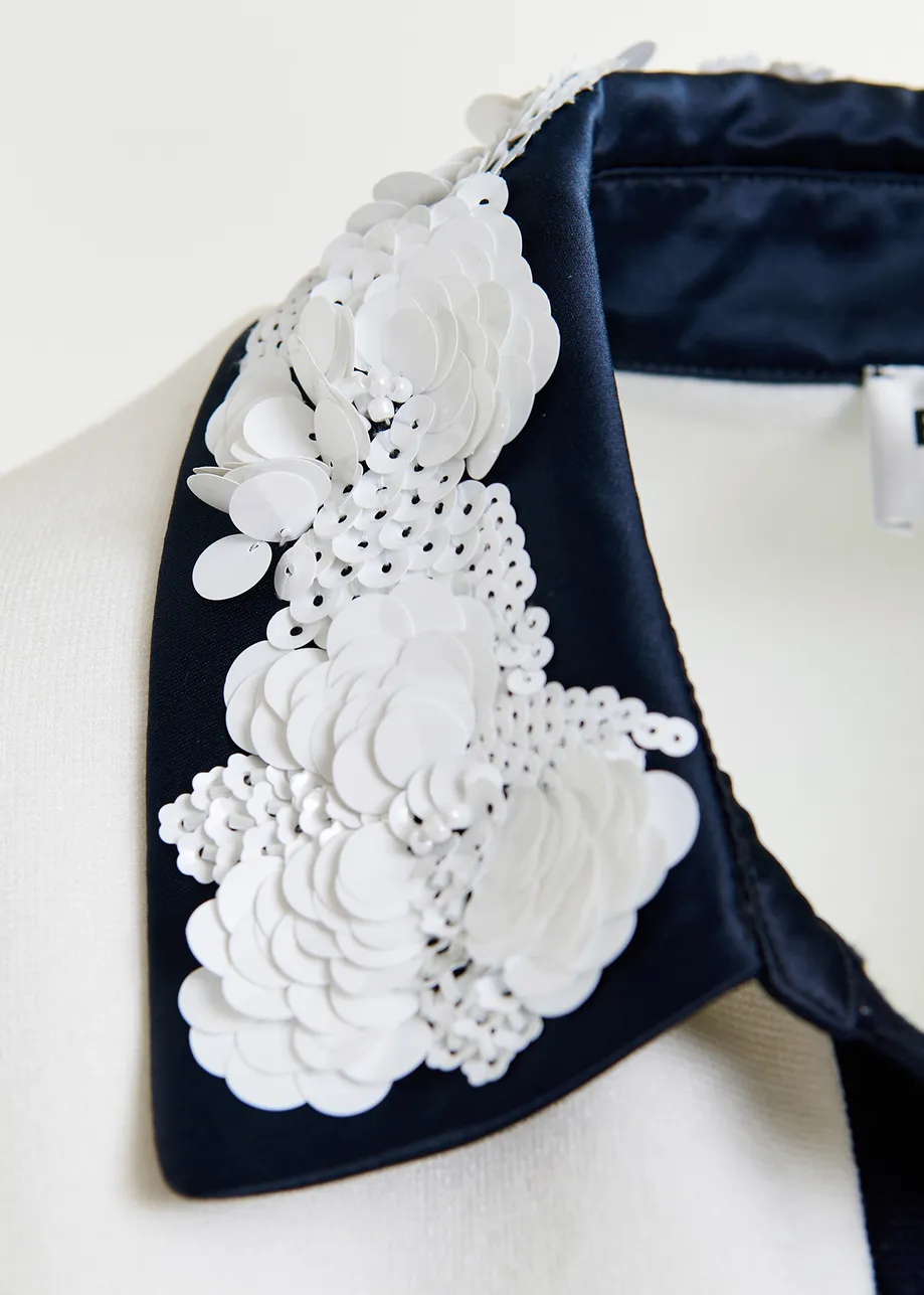 Polo bianca e nera con decorazioni di paillettes e perline
