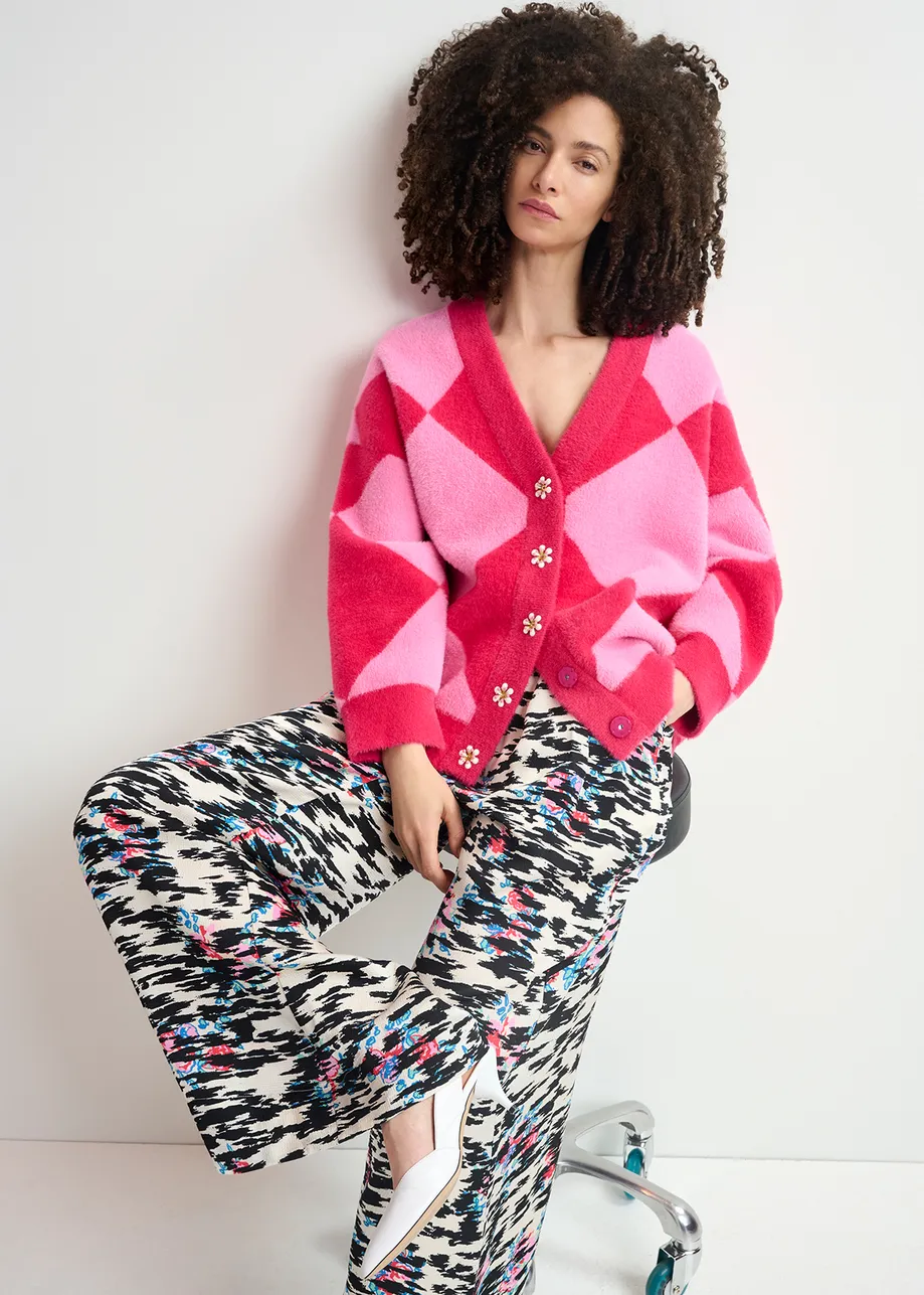 Pink harlequin-patterned knit cardigan with flower-shaped buttons

