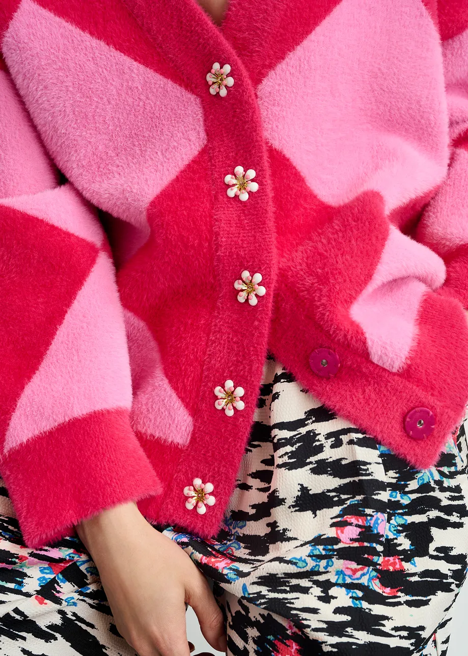 Pink harlequin-patterned knit cardigan with flower-shaped buttons

