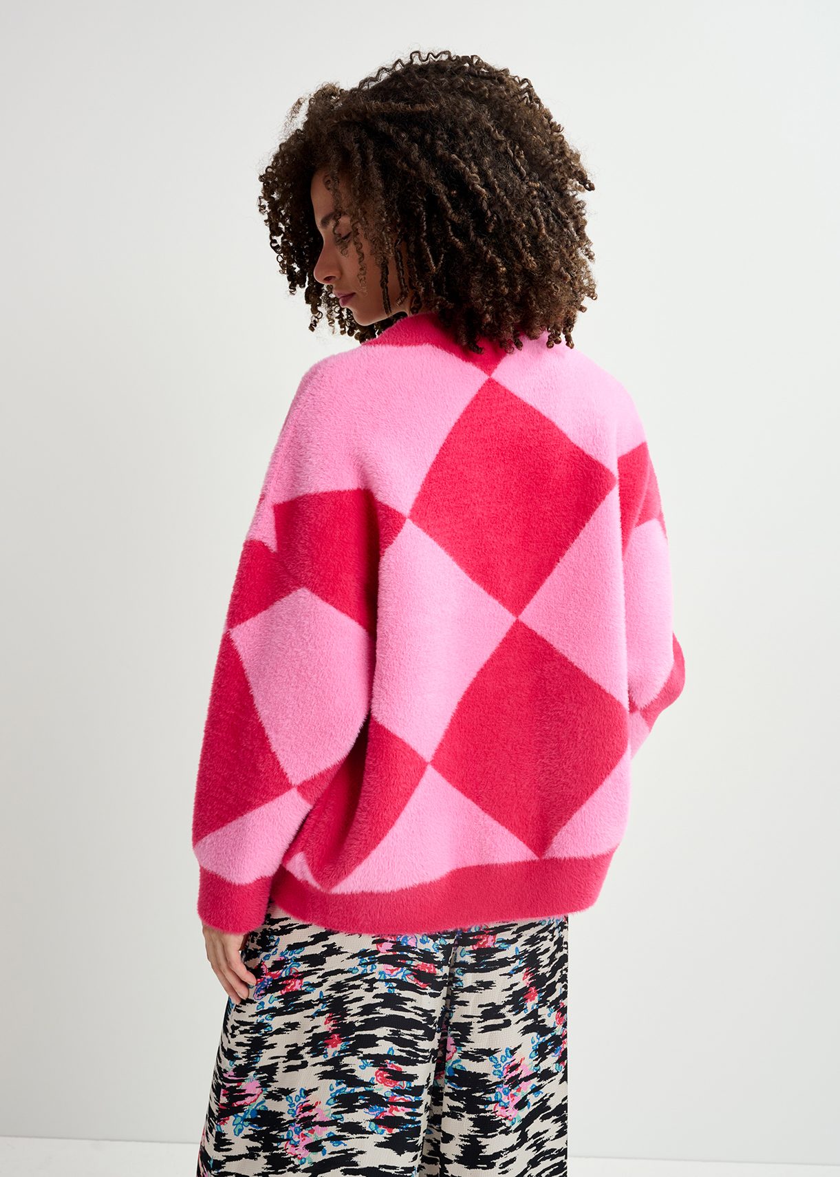Pink harlequin-patterned knit cardigan with flower-shaped buttons