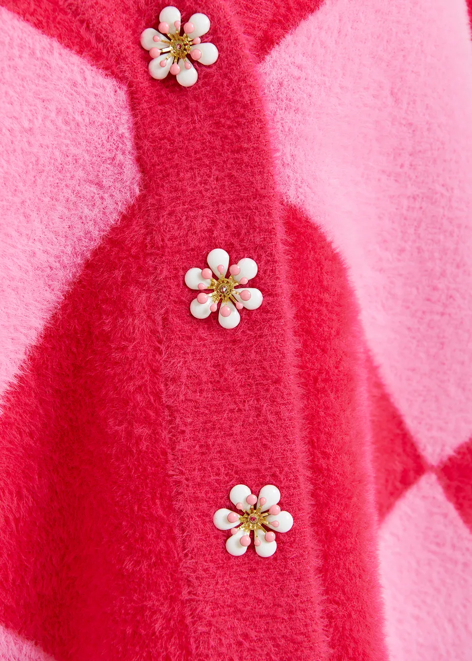 Pink harlequin-patterned knit cardigan with flower-shaped buttons

