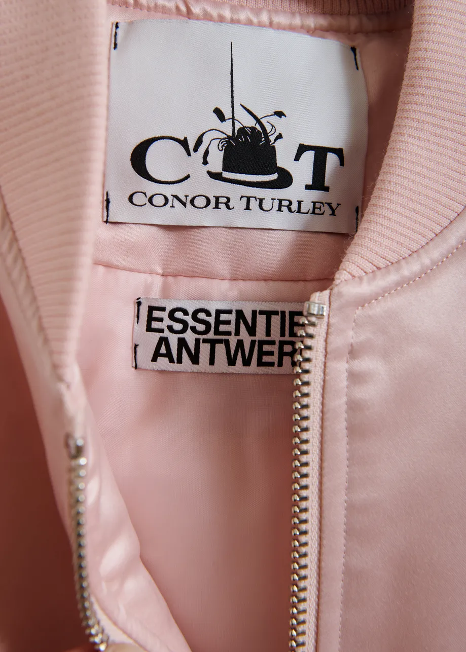 Champagne satin bomber jacket with pink and black ruffled inserts