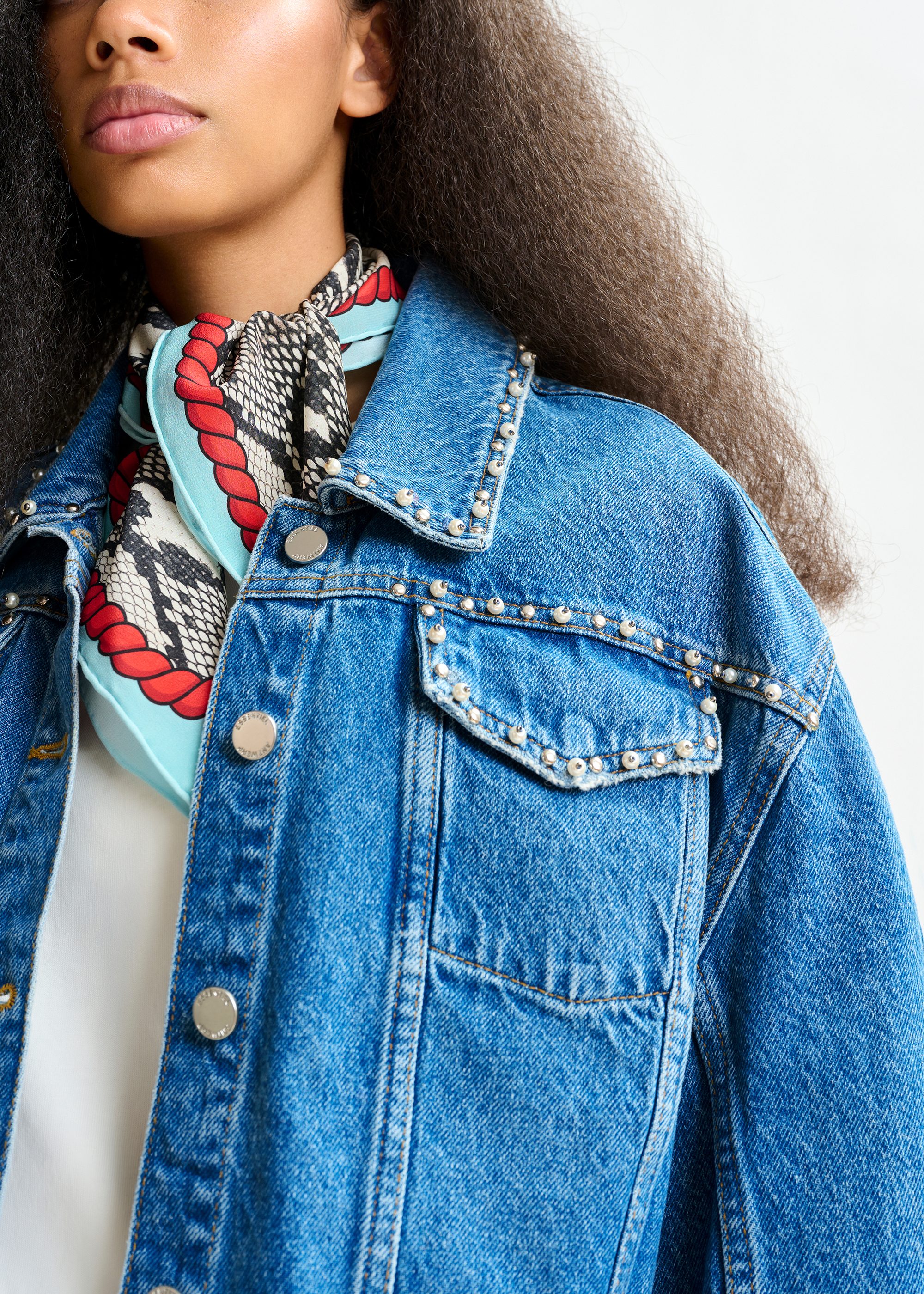 Blue cropped denim jacket with pearl and stud embellishments