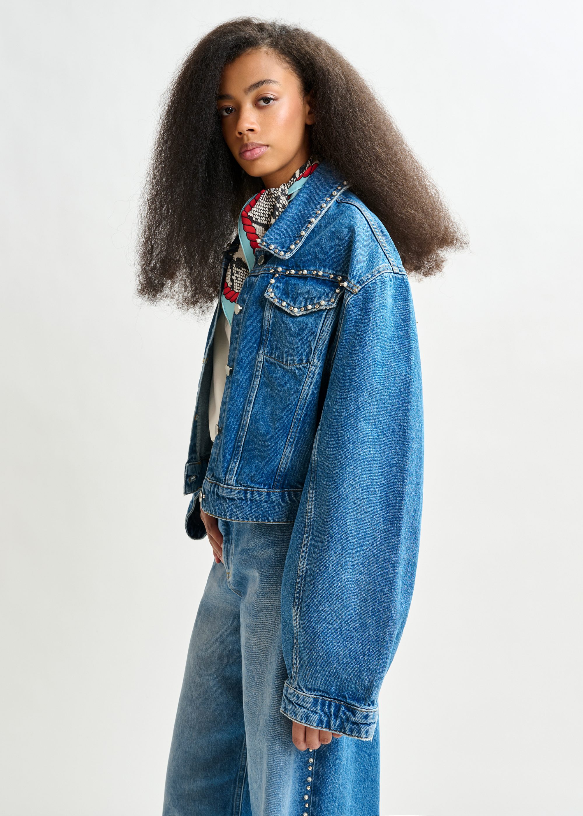 Blue cropped denim jacket with pearl and stud embellishments