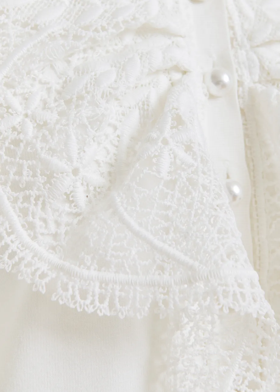 Polo sin mangas con detalles de encaje y botones de perla, blanco