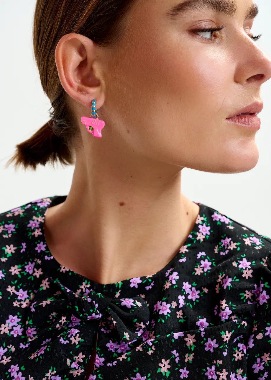 Gold and blue hoop earrings with dino and water gun pendants