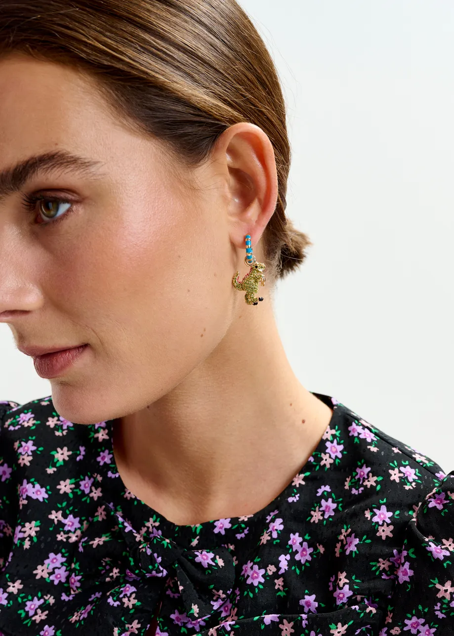 Gold and blue hoop earrings with dino and water gun pendants