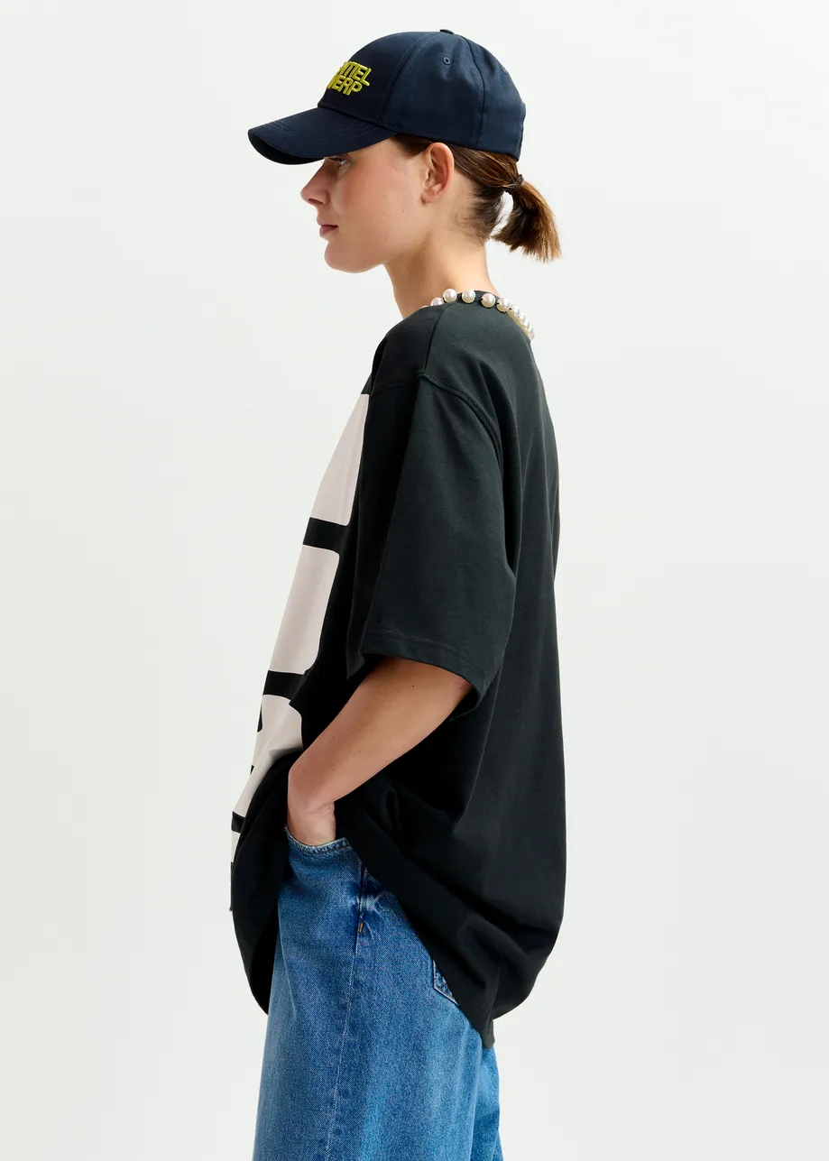 Black and white oversized cotton T-shirt with "HUH?"- print and bead embellishments