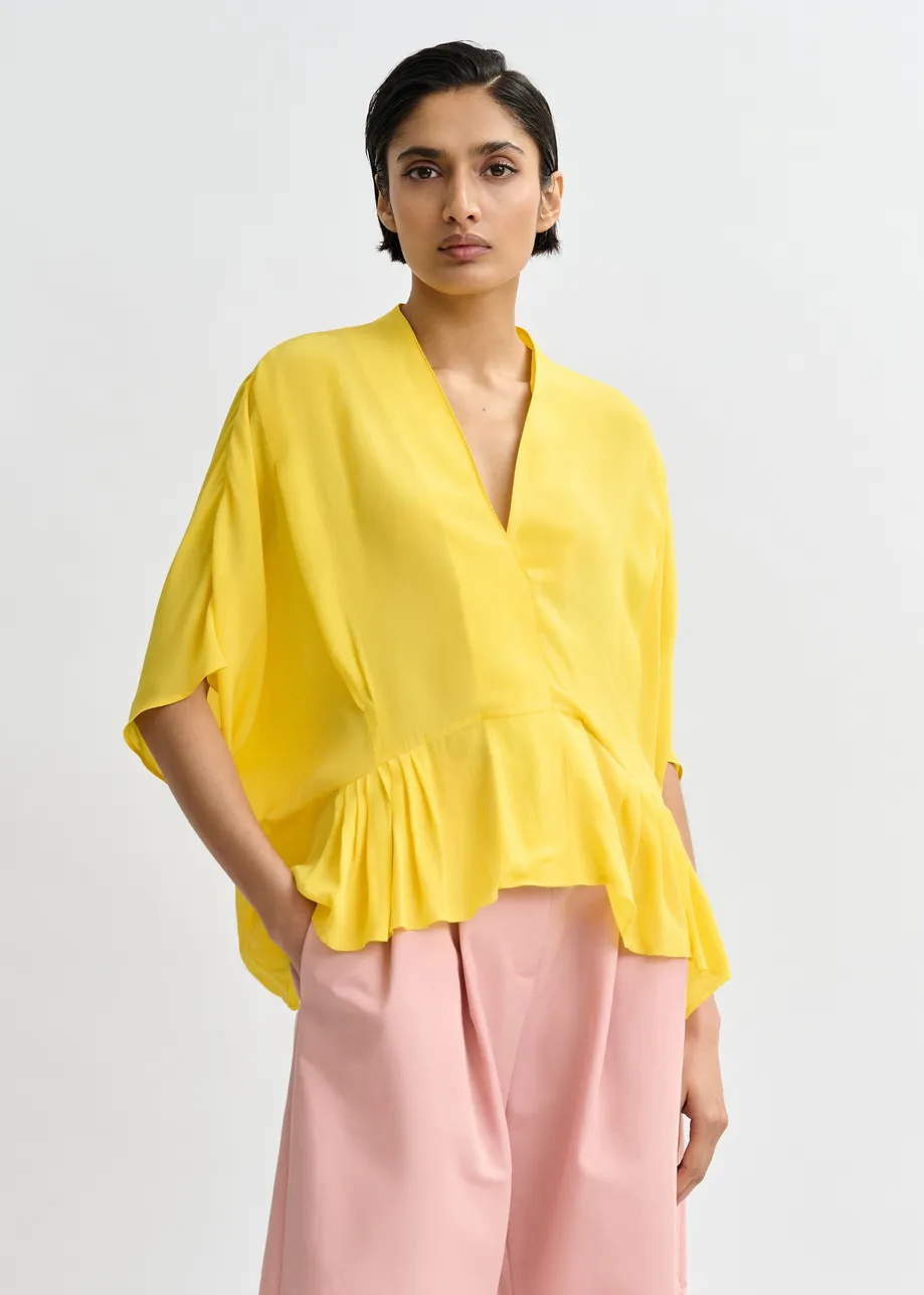 Gele oversized top met peplumzoom