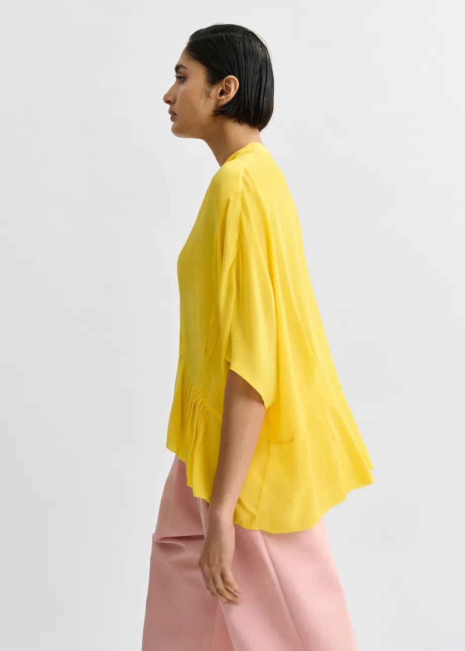 Gele oversized top met peplumzoom