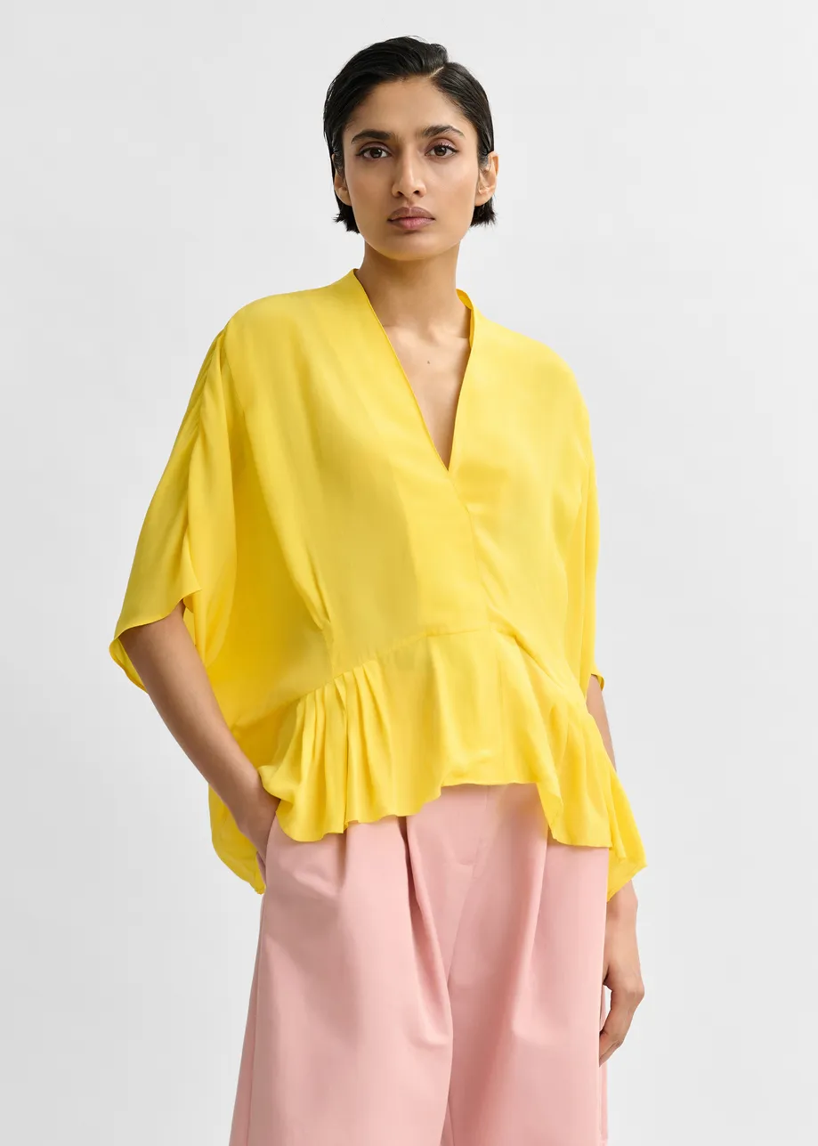 Gele oversized top met peplumzoom