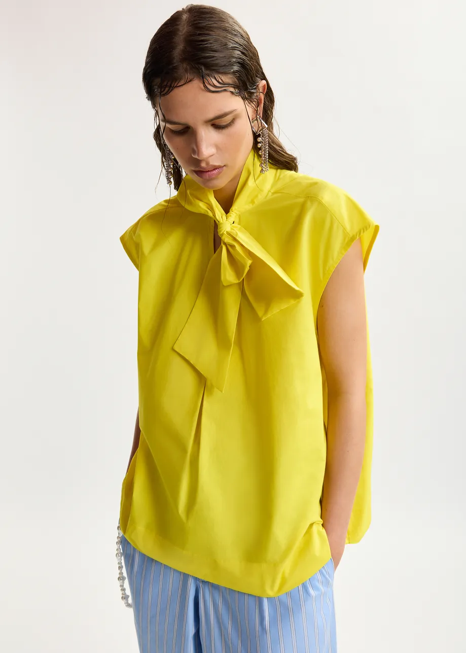 Maglia gialla senza maniche con scollo a fiocco