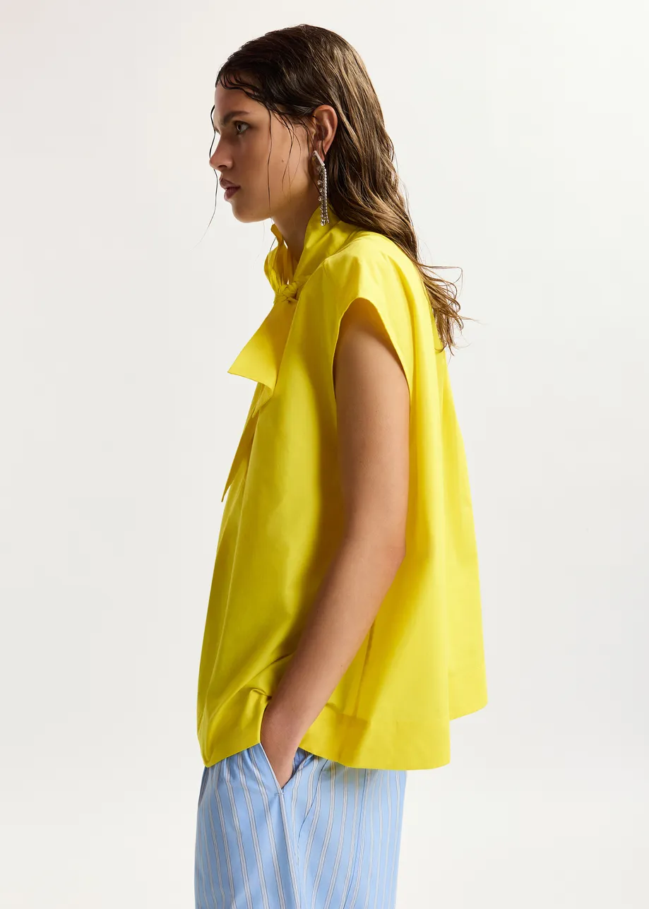 Maglia gialla senza maniche con scollo a fiocco