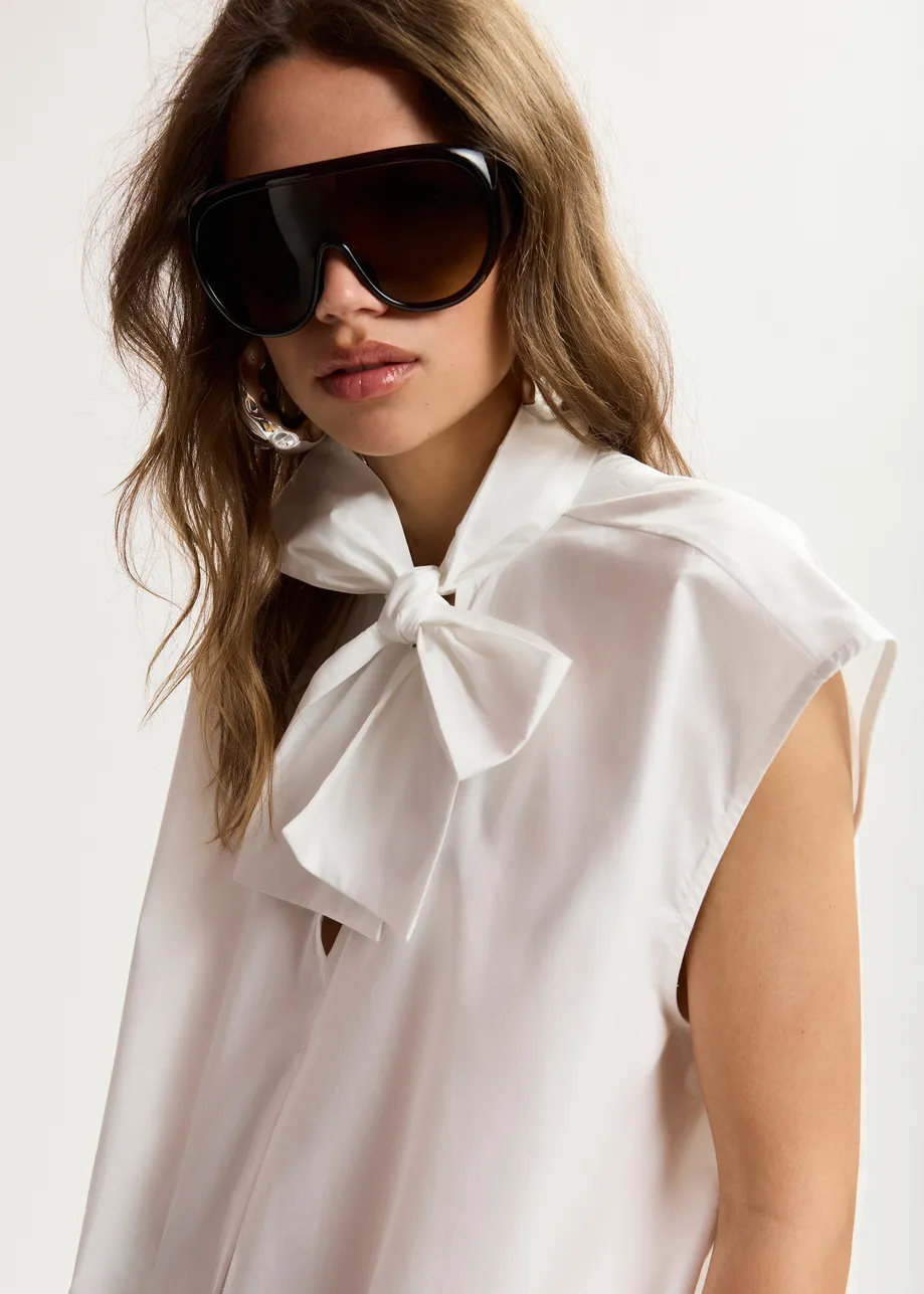 Off-white sleeveless top with tie neckline