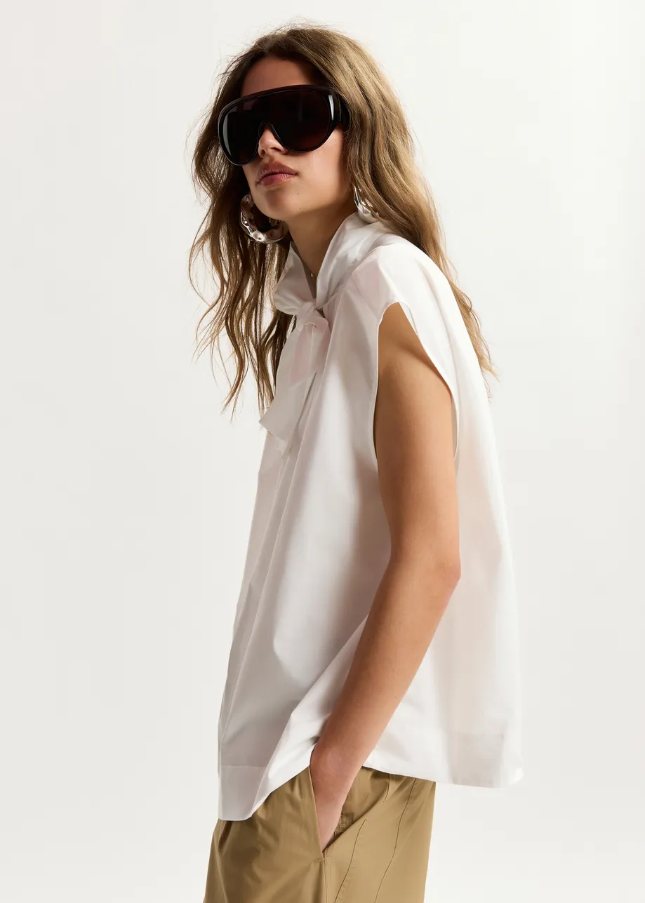 Off-white sleeveless top with tie neckline