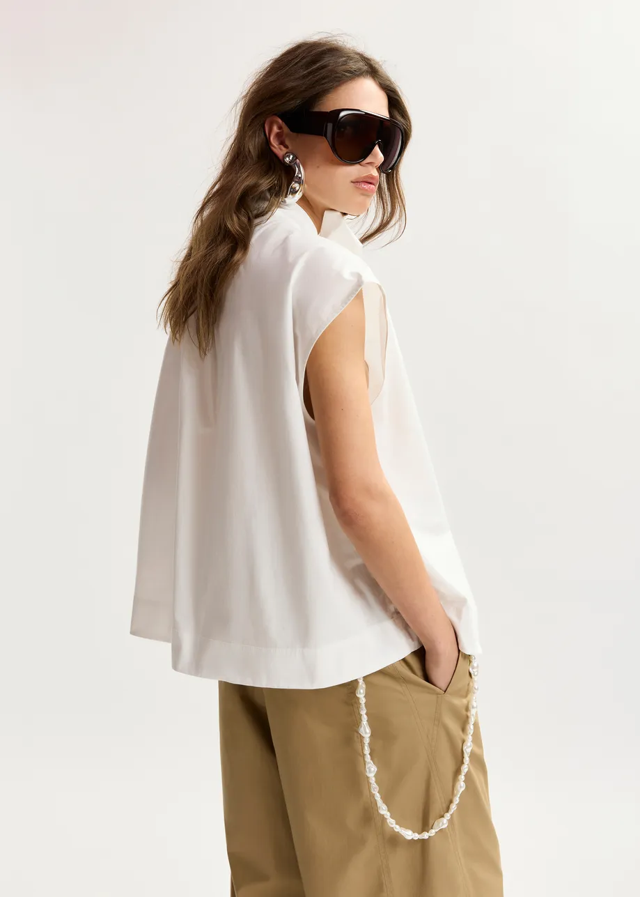 Off-white sleeveless top with tie neckline