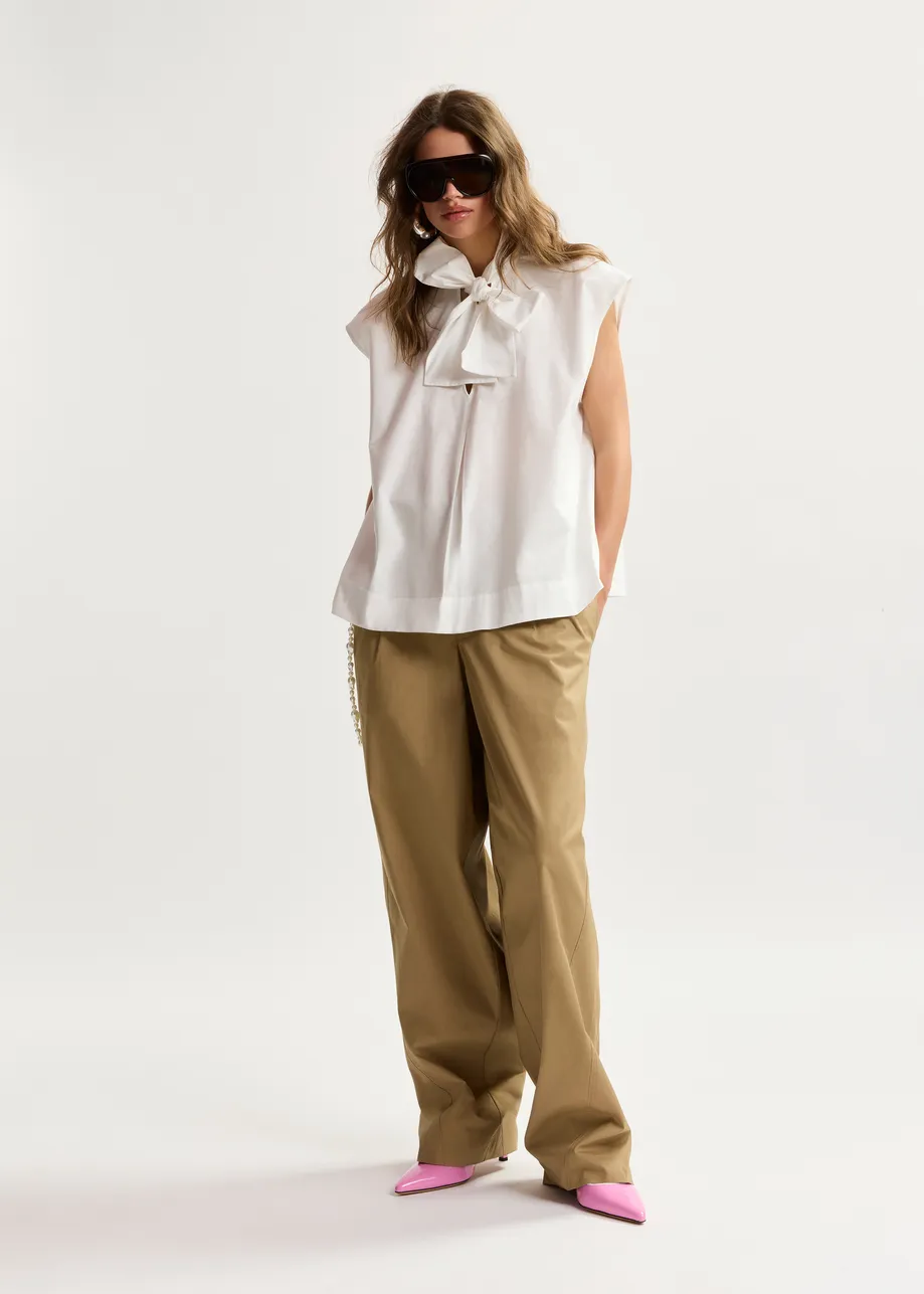 Off-white sleeveless top with tie neckline
