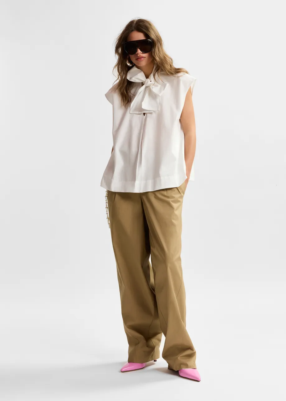 Off-white sleeveless top with tie neckline