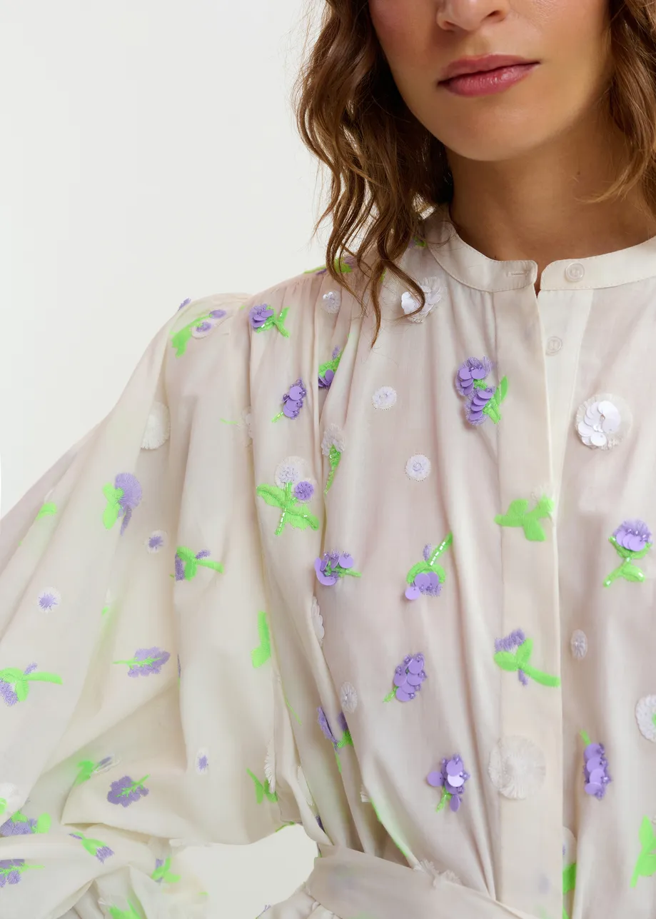 Off-white knee-length dress with mandarin collar and purple and green embellishments